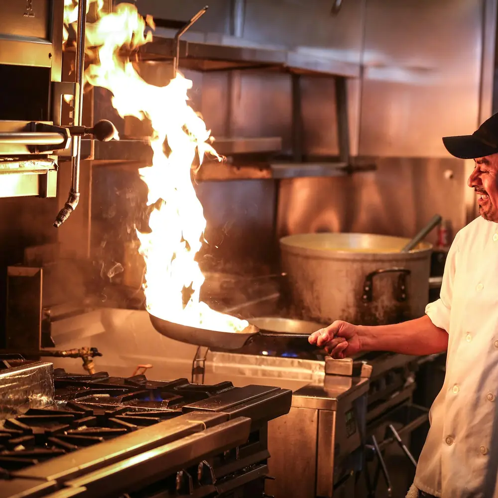 A chef cooking over the stove